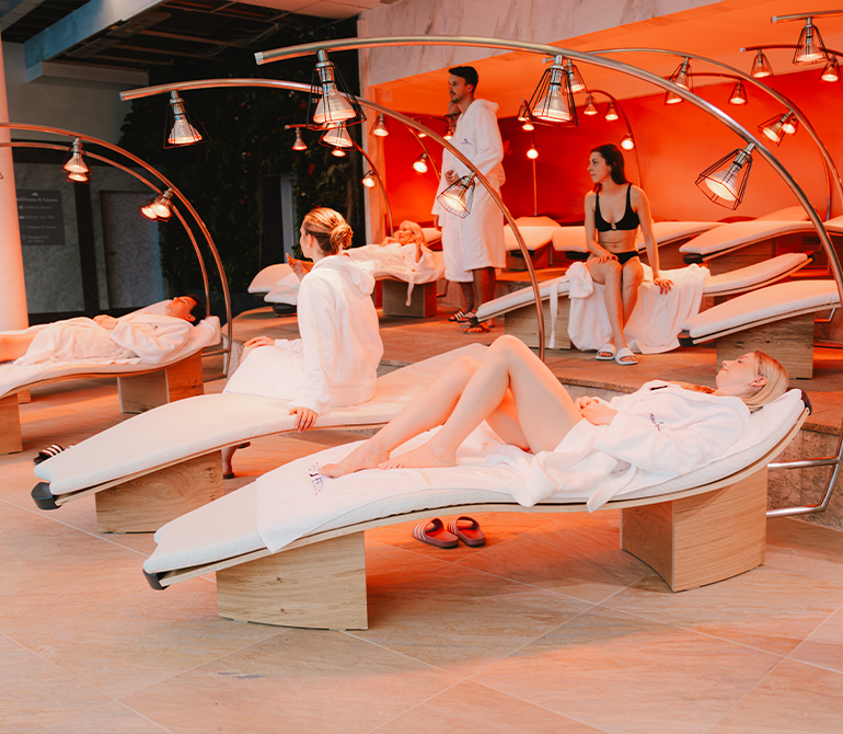 Modern infrared loungers in a softly lit relaxation room, featuring an ergonomic design and a soothing wellness atmosphere