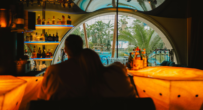Couple sitting at the bar and looking at the wave pool
