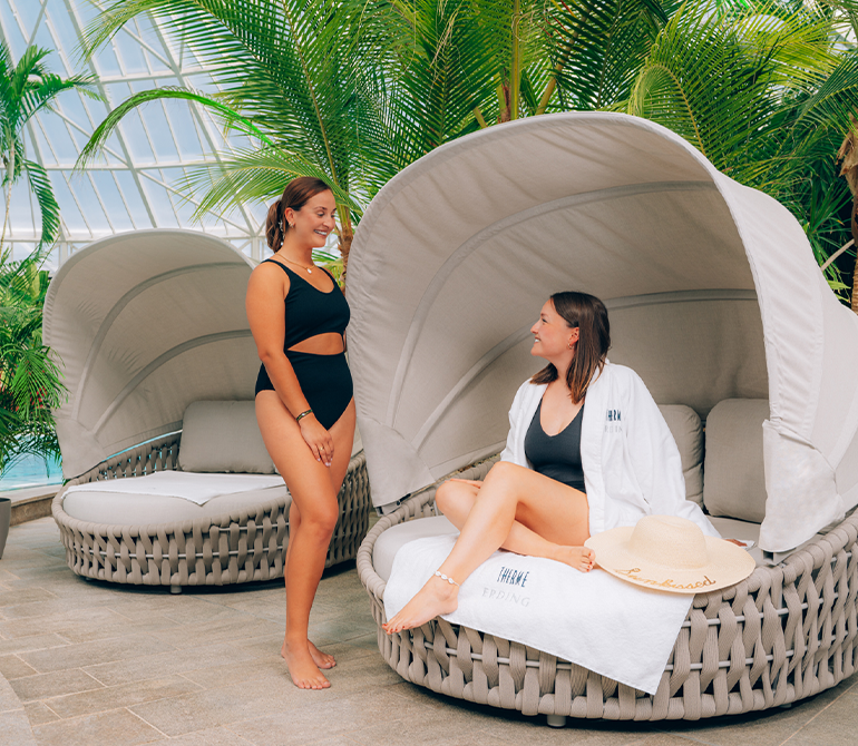 Zwei Frauen entspannen auf einer offenen, gemütlichen Liege.