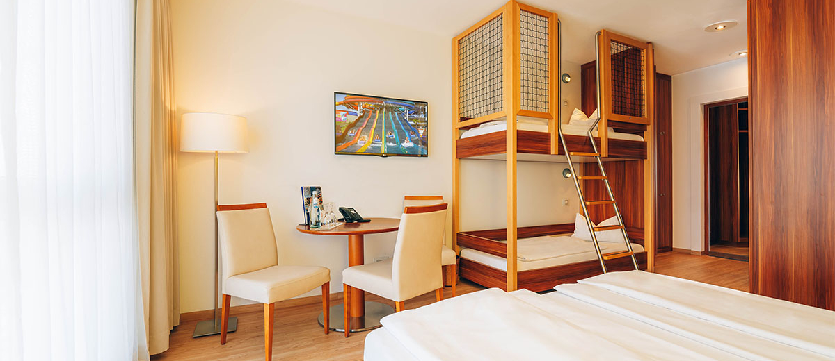 Hotel Victory Therme Erding Bellezza View of a bright hotel room with double bed, bunk bed, table and chairs