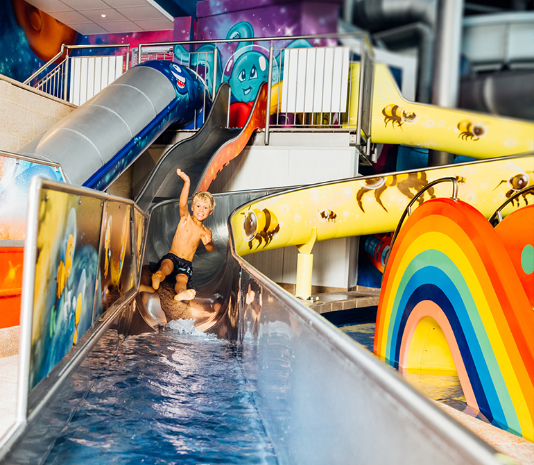 Child slides down the colorful Sunny, Moon, and Star Slide.