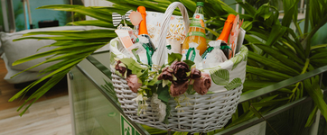 Geschenkkorb mit Blumen, Getränken und Pflegeprodukten auf Liege in Therme Erding