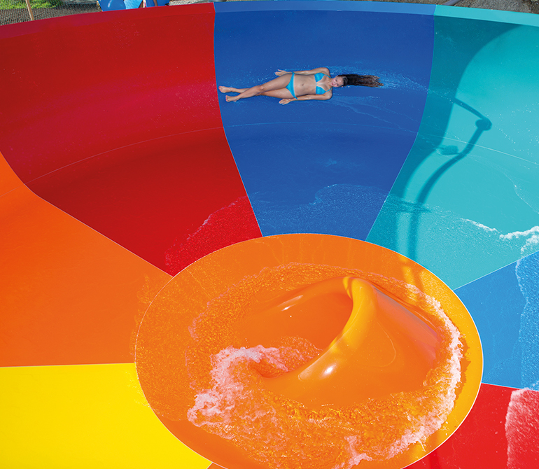 Woman slides very quickly through a colorful funnel. 