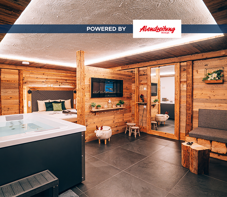 Ein großer Whirlpool in einem Raum im Hüttenstil mit luxuriöser Ausstattung.